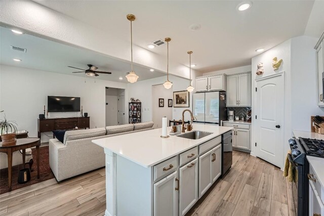12904 Cerro Castellan Trce, Manor, TX 78653 - kitchen featuring black gas range, freestanding refrigerator, dishwashing machine, light wood finished floors, and recessed lighting