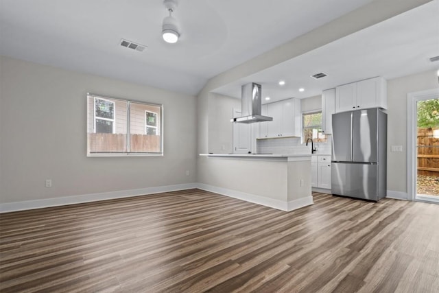 4913 Single Shot Cir, Austin, TX 78723 - kitchen featuring freestanding refrigerator, range hood, dark wood-style flooring, white cabinetry, and light countertops