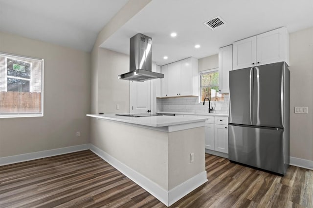 4913 Single Shot Cir, Austin, TX 78723 - kitchen with freestanding refrigerator, island exhaust hood, dark wood-type flooring, a peninsula, and white cabinets