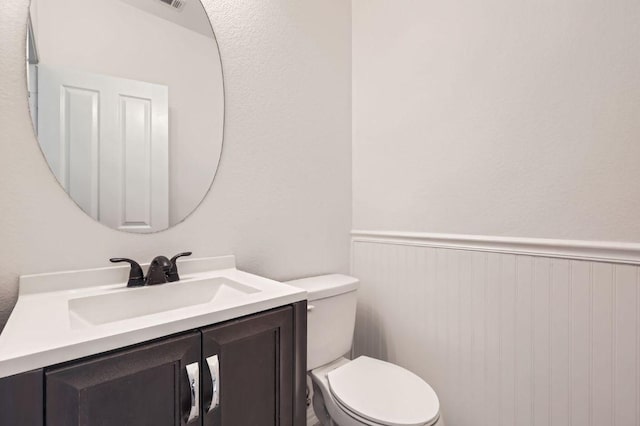 4508 Three Arrows Ct, Cedar Park, TX 78613 - half bathroom with toilet, vanity, and a wainscoted wall