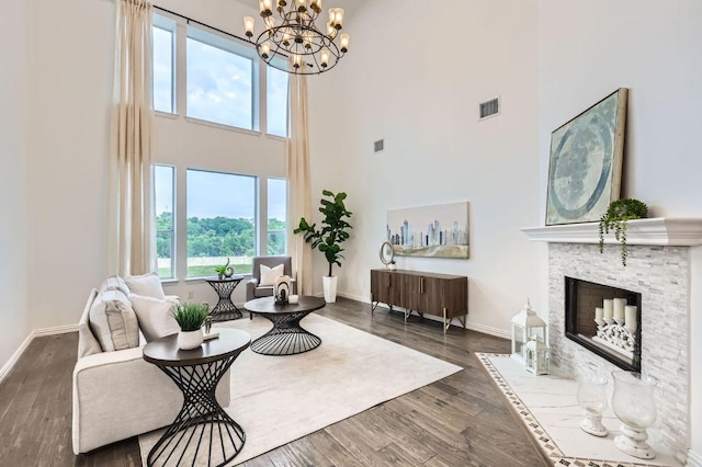 4508 Three Arrows Ct, Cedar Park, TX 78613 - living area featuring a towering ceiling, baseboards, dark wood-type flooring, a chandelier, and a fireplace with flush hearth