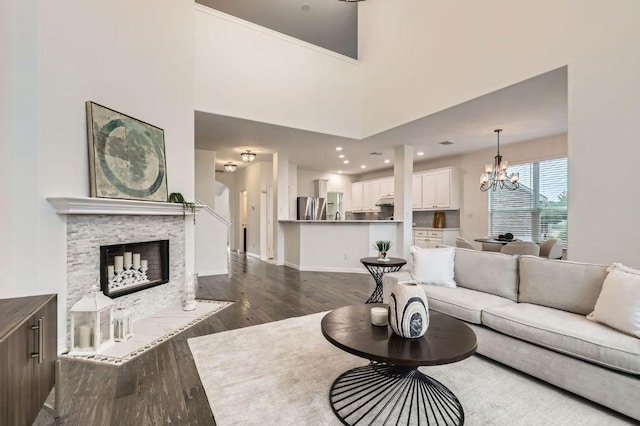 4508 Three Arrows Ct, Cedar Park, TX 78613 - living area with dark wood-style flooring, a chandelier, a fireplace, baseboards, and recessed lighting