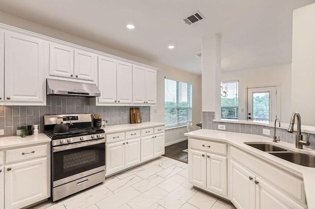 4508 Three Arrows Ct, Cedar Park, TX 78613 - kitchen featuring gas range, under cabinet range hood, a sink, light marble finish flooring, and white cabinets
