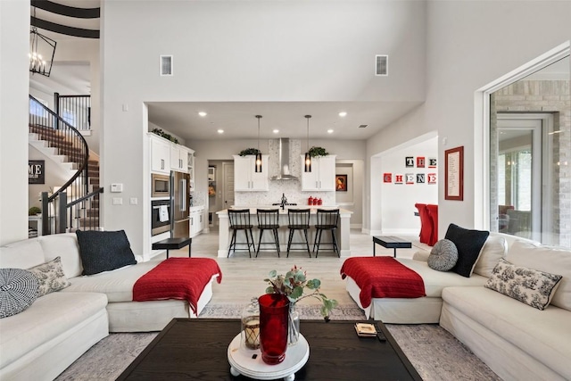 17804 Hattie Trce, Austin, TX 78738 - living area featuring a towering ceiling, stairs, light wood-style floors, baseboards, and recessed lighting