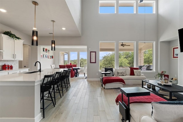 17804 Hattie Trce, Austin, TX 78738 - living area with a towering ceiling, light wood finished floors, a ceiling fan, baseboards, and recessed lighting