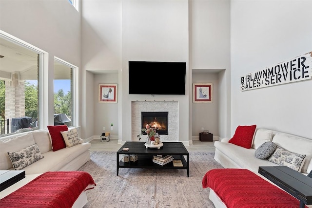 17804 Hattie Trce, Austin, TX 78738 - living room with a towering ceiling, a lit fireplace, wood finished floors, and baseboards