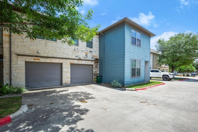1201 Grove Blvd Unit 1103, Austin, TX 78741 - view of property exterior with stone siding, driveway, and an attached garage