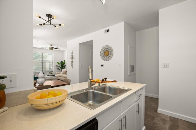 1201 Grove Blvd Unit 1103, Austin, TX 78741 - kitchen with a sink, light countertops, a chandelier, white cabinets, and open floor plan
