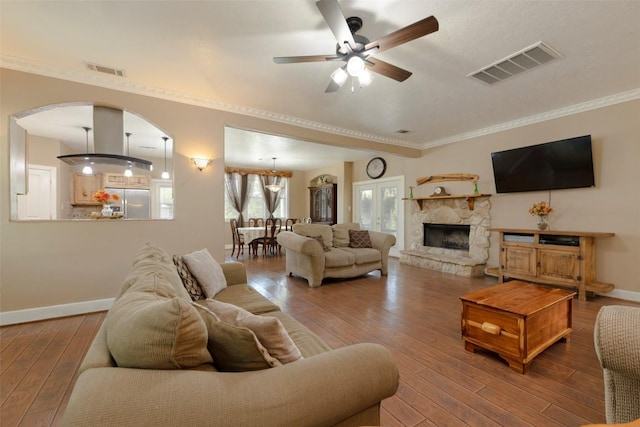 15055 Fm 32, Blanco, TX 78606 - living room featuring ceiling fan, hardwood / wood-style floors, baseboards, arched walkways, and ornamental molding