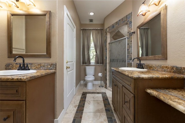 15055 Fm 32, Blanco, TX 78606 - full bathroom with inlaid floor details, two vanities, a shower stall, baseboards, and toilet
