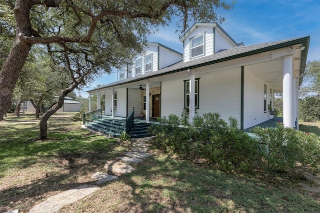 15055 Fm 32, Blanco, TX 78606 - farmhouse-style home featuring covered porch, a front lawn, an outbuilding, a ceiling fan, and roof with shingles