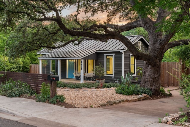 1904 S 6th St, Austin, TX 78704 - view of front facade featuring a standing seam roof, covered porch, a metal roof, and concrete driveway