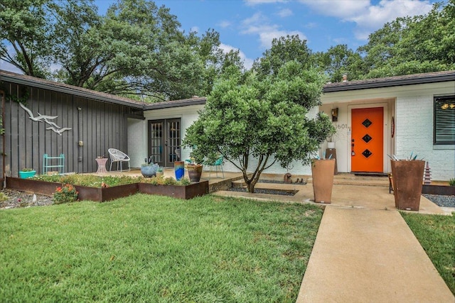 1601 E 19th St, Georgetown, TX 78626 - view of front of home featuring french doors, a front yard, and board and batten siding