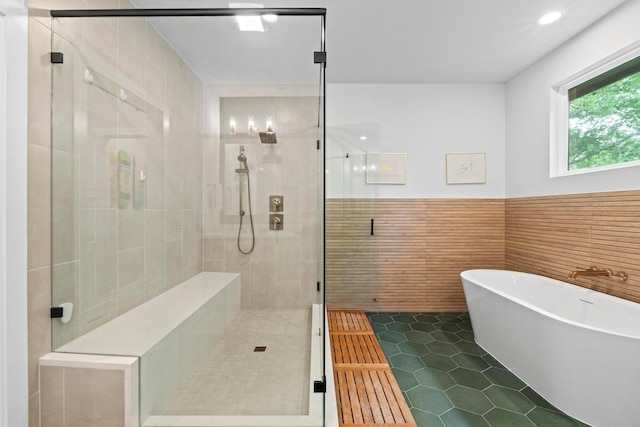 1708 Morrow St, Austin, TX 78757 - full bath featuring a shower stall, tile patterned flooring, a freestanding tub, tile walls, and a wainscoted wall