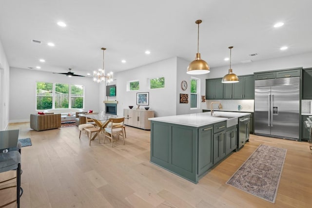 1708 Morrow St, Austin, TX 78757 - kitchen with appliances with stainless steel finishes, green cabinets, a sink, light countertops, and open floor plan