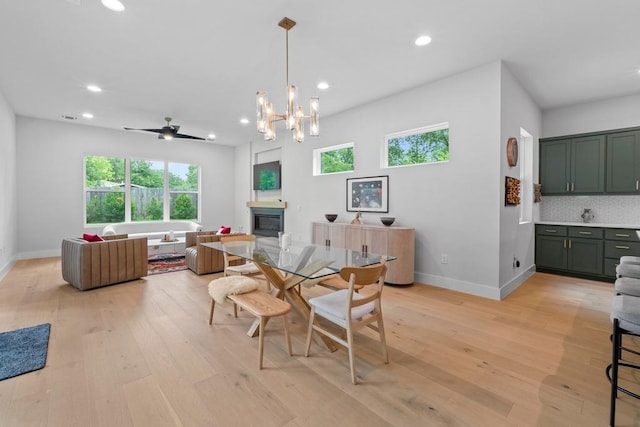 1708 Morrow St, Austin, TX 78757 - dining room featuring healthy amount of natural light, a glass covered fireplace, recessed lighting, and light wood-style flooring