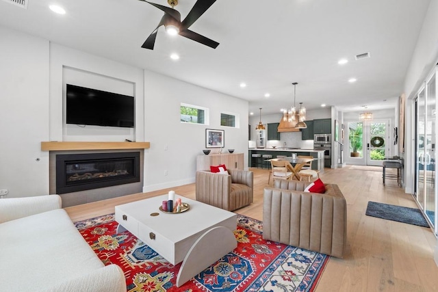 1708 Morrow St, Austin, TX 78757 - living area featuring a ceiling fan, light wood-type flooring, healthy amount of natural light, recessed lighting, and a glass covered fireplace