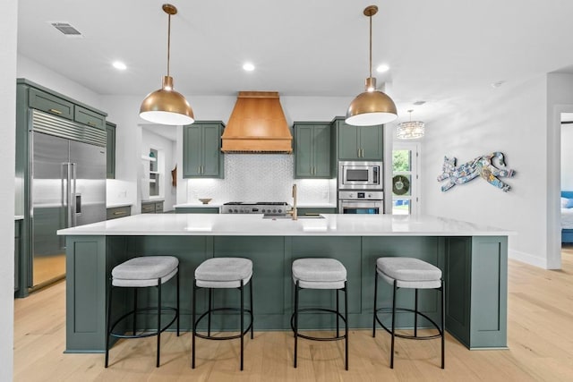 1708 Morrow St, Austin, TX 78757 - kitchen with green cabinetry, built in appliances, custom range hood, a sink, and light wood-style flooring