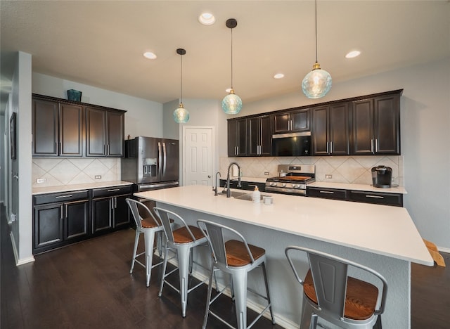 6900 Midlothian Dr, Austin, TX 78754 - kitchen with appliances with stainless steel finishes, a sink, backsplash, dark wood-style flooring, and a breakfast bar