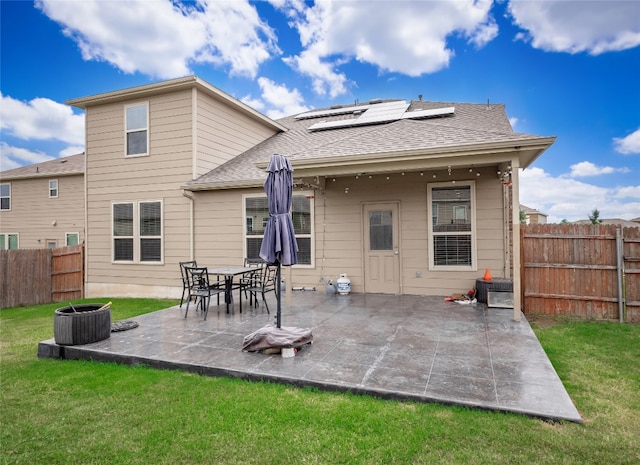 6900 Midlothian Dr, Austin, TX 78754 - back of property featuring roof mounted solar panels, a patio area, and roof with shingles