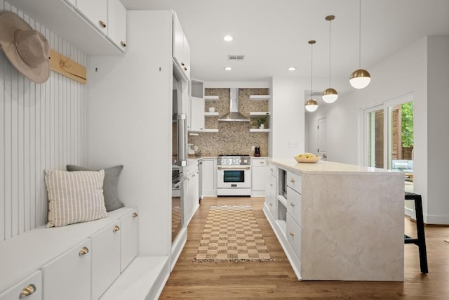 1002 Payne Ave, Austin, TX 78757 - kitchen with open shelves, stove, wall chimney exhaust hood, light wood-style floors, and tasteful backsplash