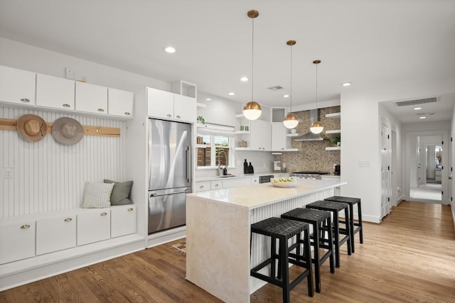 1002 Payne Ave, Austin, TX 78757 - kitchen featuring stainless steel fridge, open shelves, light countertops, a kitchen island, and tasteful backsplash