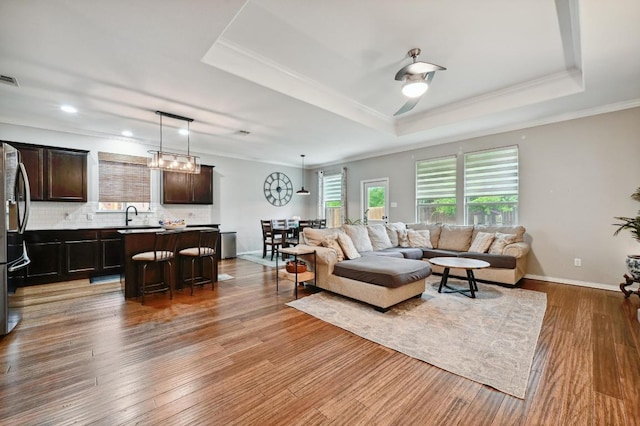 1192 Clark Brothers Dr, Buda, TX 78610 - living area featuring a raised ceiling, wood finished floors, ornamental molding, baseboards, and recessed lighting
