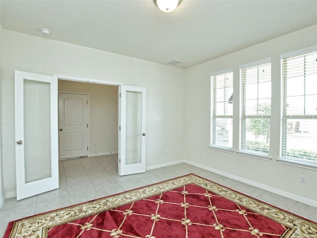 913 Swan Flower St, Leander, TX 78641 - empty room with french doors, healthy amount of natural light, light tile patterned floors, and a smoke detector
