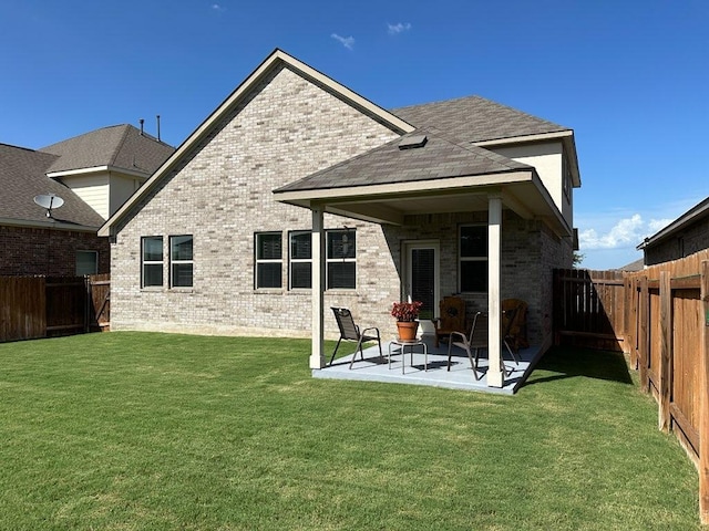 913 Swan Flower St, Leander, TX 78641 - back of house with a patio, brick siding, a fenced backyard, and a shingled roof