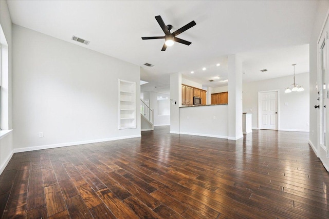 15405 Montoya Cv, Austin, TX 78717 - unfurnished living room with dark wood finished floors, a ceiling fan, a chandelier, and baseboards
