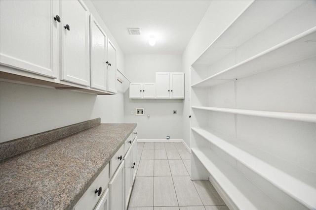 15405 Montoya Cv, Austin, TX 78717 - laundry area with hookup for a washing machine, hookup for an electric dryer, cabinet space, baseboards, and light tile patterned floors