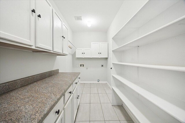 15405 Montoya Cv, Austin, TX 78717 - laundry area featuring hookup for an electric dryer, hookup for a washing machine, cabinet space, light tile patterned flooring, and hookup for a gas dryer