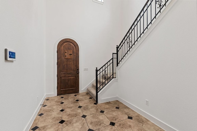 1036 Liberty Park Dr Unit 3, Austin, TX 78746 - foyer with arched walkways, a high ceiling, stairs, and light tile patterned floors
