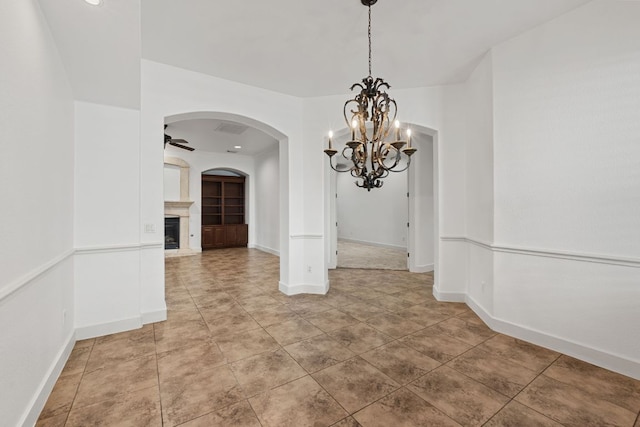 1036 Liberty Park Dr Unit 3, Austin, TX 78746 - unfurnished dining area with a chandelier, a fireplace with raised hearth, arched walkways, light tile patterned floors, and ceiling fan