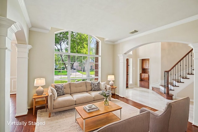 6611 Haughton Dr, Spring, TX 77389 - living room featuring decorative columns, arched walkways, wood finished floors, crown molding, and stairway