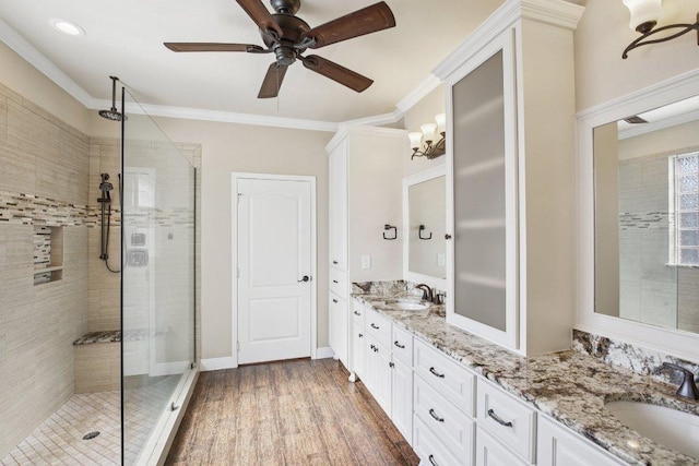 6611 Haughton Dr, Spring, TX 77389 - full bathroom with double vanity, a tile shower, a ceiling fan, ornamental molding, and wood finished floors