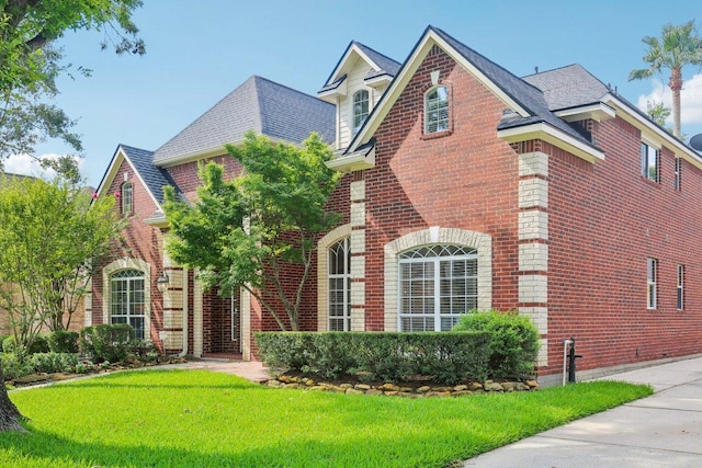 6611 Haughton Dr, Spring, TX 77389 - view of front of property featuring brick siding, a front lawn, and roof with shingles