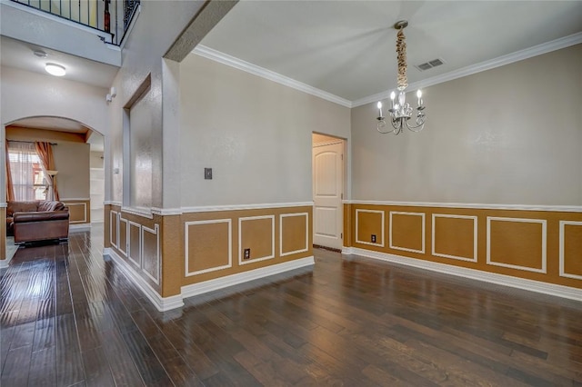 3107 Magnolia Mnr, New Braunfels, TX 78130 - unfurnished dining area with arched walkways, a chandelier, dark wood-style flooring, crown molding, and a wainscoted wall