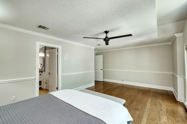 1506 Spiderlily Vw, Cedar Park, TX 78613 - bedroom featuring wood finished floors, crown molding, a textured ceiling, baseboards, and ensuite bathroom