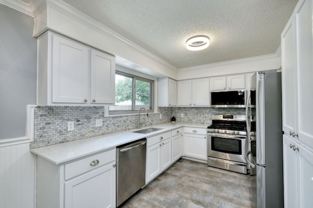 1506 Spiderlily Vw, Cedar Park, TX 78613 - kitchen featuring appliances with stainless steel finishes, a textured ceiling, a sink, white cabinets, and tasteful backsplash