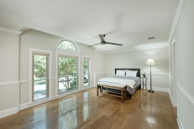 1506 Spiderlily Vw, Cedar Park, TX 78613 - bedroom with wood finished floors, a textured ceiling, ornamental molding, ceiling fan, and baseboards