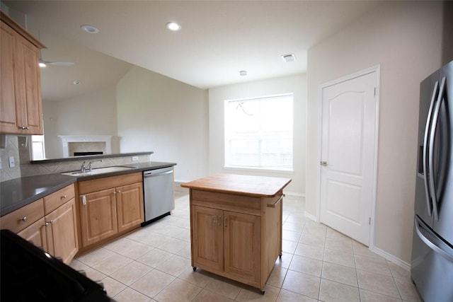 2308 Lou John St, Austin, TX 78727 - kitchen featuring appliances with stainless steel finishes, a fireplace, a sink, light tile patterned flooring, and recessed lighting