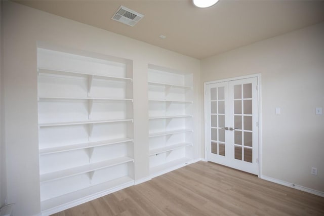 2308 Lou John St, Austin, TX 78727 - spare room with french doors, wood finished floors, built in shelves, and baseboards