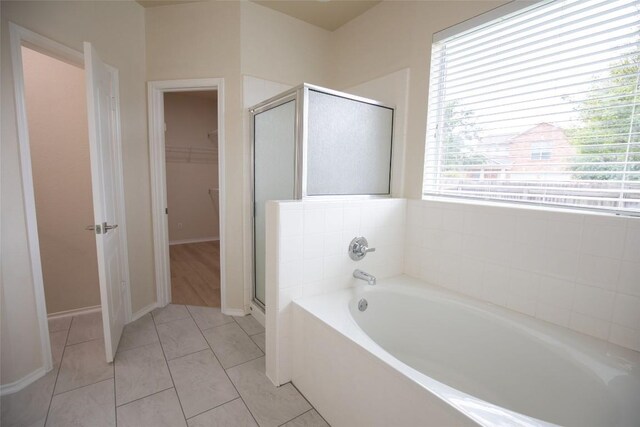 2308 Lou John St, Austin, TX 78727 - bathroom with a stall shower, a garden tub, a walk in closet, tile patterned floors, and baseboards