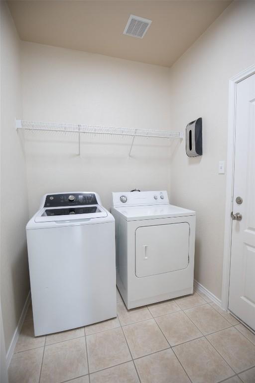 2308 Lou John St, Austin, TX 78727 - laundry area featuring washing machine and clothes dryer and light tile patterned floors