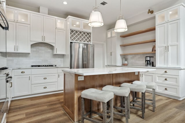 800 Newcastle Dr, Austin, TX 78745 - kitchen with freestanding refrigerator, tasteful backsplash, a center island, white cabinetry, and recessed lighting