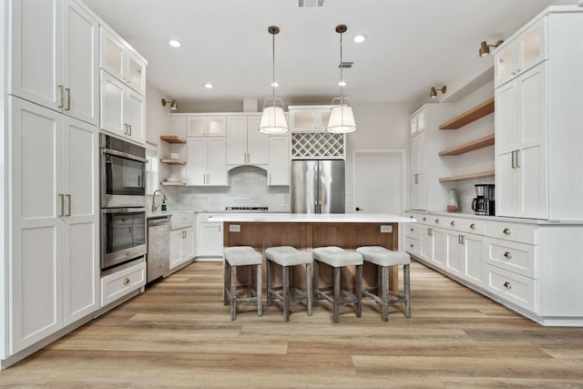 800 Newcastle Dr, Austin, TX 78745 - kitchen with open shelves, stainless steel appliances, a center island, white cabinetry, and recessed lighting