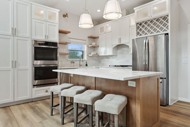 800 Newcastle Dr, Austin, TX 78745 - kitchen with appliances with stainless steel finishes, open shelves, light wood-style floors, decorative backsplash, and recessed lighting