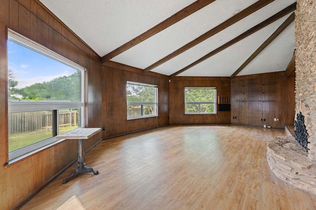 600 Little Oak Dr, Austin, TX 78753 - unfurnished living room with beamed ceiling, wood walls, light wood finished floors, and high vaulted ceiling
