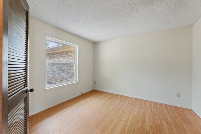 600 Little Oak Dr, Austin, TX 78753 - spare room with wood finished floors, baseboards, and a textured ceiling
